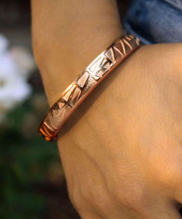 Bangle & Band rose gold hair tie bracelet; this beautiful piece of jewelry features a narrow channel on the side of the bangle for the purpose of holding a hair tie.